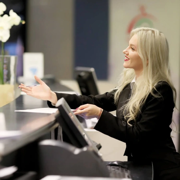 Receptionist at hotel front desk, representing hospitality services