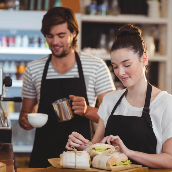 Two baristas preparing drinks in a cafe, representing HoReCa sector